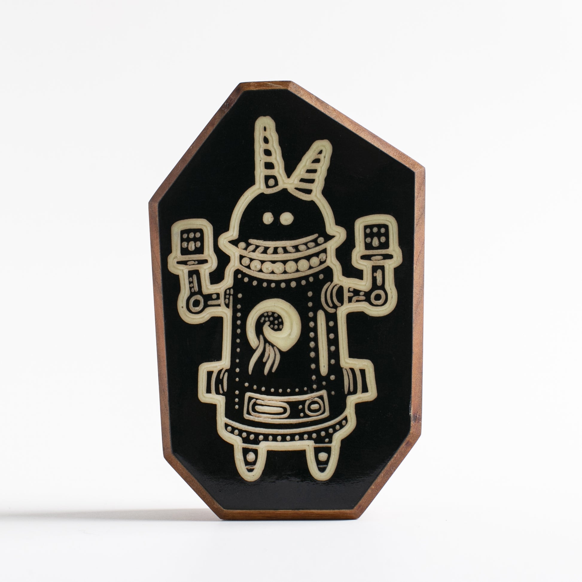 Handcrafted glow-in-the-dark talisman featuring Buzznork the robotic guardian