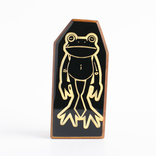 Floopfin, a frog like creature handcrafted cherry wood talisman front view with glow-in-the-dark accents.